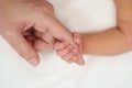 Newborn baby hand holding index finger of mother on bed Royalty Free Stock Photo