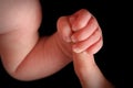 Newborn baby holding mother's finger