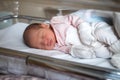 Newborn baby in the hospital. The baby has just been born. Sleepy baby lies in the crib