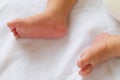 Newborn baby infant feet on white bed