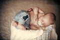 Newborn baby in jeans sleep in basket on floor Royalty Free Stock Photo