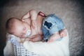 Newborn baby in jeans sleep in basket on floor Royalty Free Stock Photo