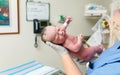 Newborn baby just born being held by nurse in hospital labor and delivery room Royalty Free Stock Photo