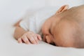 Newborn baby kid sleeping on his tummy on bed at home. Asian child bottom up sleeping position Royalty Free Stock Photo