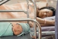 Newborn baby laying in crib with his mother lying on bed side Royalty Free Stock Photo