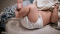 Newborn baby legs in diaper, lying on white bed Royalty Free Stock Photo