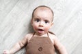 Newborn baby. A little boy in brown bodysuit . Beautiful portrait of a toddler. Big-eyed baby. Royalty Free Stock Photo