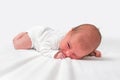 Newborn baby is lying on belly on white blanket