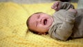 Newborn baby lying and crying suffering abdominal colic, emergence of tooth Royalty Free Stock Photo