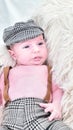 a newborn baby is lying on a white fur in a cap and with a guitar Royalty Free Stock Photo