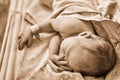 A newborn baby with a maternity hospital bracelet on his arm is sleeping in a crib. A newly born child in a clinic bed behind a Royalty Free Stock Photo