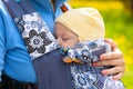 Newborn baby and mother outdoors walking with sling. Royalty Free Stock Photo