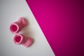 Newborn baby pink socks on pink and white diagonally divided background Royalty Free Stock Photo