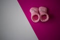 Newborn baby pink socks on pink and white divided background, copy space Royalty Free Stock Photo
