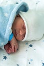 Newborn Baby Red Cute Face Portrait Early Days Sleeping In Medical Glass Bed On Blue Background. Child At Start Minutes Royalty Free Stock Photo