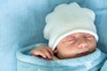 Newborn Baby Red Cute Face Portrait Early Days Sleeping In Medical Glass Bed On Blue Background. Child At Start Minutes Royalty Free Stock Photo