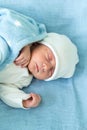 Newborn Baby Red Cute Face Portrait Early Days Sleeping In Medical Glass Bed On Blue Background. Child At Start Minutes Royalty Free Stock Photo