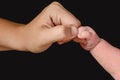 A newborn baby's arm with a clenched fist bumps into its mother's fist. Royalty Free Stock Photo