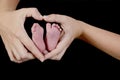The newborn baby`s feet are in the heart-shaped hands of his mother. Focus on the foot and hands on the right. Royalty Free Stock Photo