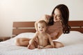 Newborn baby sitting home with her mother playing and smiling. Mom enjoying her motherhood. Royalty Free Stock Photo