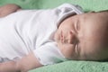 Newborn baby sleeping on a green blanket Royalty Free Stock Photo