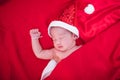 Newborn baby sleeping on santa het and red background Royalty Free Stock Photo