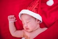 Newborn baby sleeping on santa het and red background Royalty Free Stock Photo
