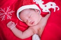 Newborn baby sleeping on santa het and red background Royalty Free Stock Photo