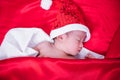 Newborn baby sleeping on santa het and red background Royalty Free Stock Photo