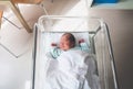 Newborn baby is sleeping in small transparent portable plastic bed. Royalty Free Stock Photo