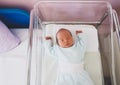 Newborn baby is sleeping in small transparent portable plastic bed. Baby first days of life is lying in a hospital crib after Royalty Free Stock Photo