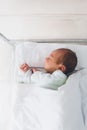 Newborn baby is sleeping in small transparent portable plastic bed. Royalty Free Stock Photo