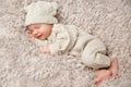 Newborn Baby smiling in Sleep on fluffy Blanket. One Month Child in knitted Hat Woolen Suit. Happy Infant Boy sleeping on Fur Bed Royalty Free Stock Photo