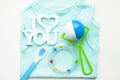 Newborn baby story. T-shirt and children's toys, scissors, baby bottle, nipple, hairbrush on white background Royalty Free Stock Photo