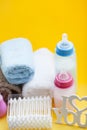 Newborn baby story. Towels and children's toys, scissors, baby bottle, nipple, hairbrush on yellow background Royalty Free Stock Photo