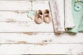 Newborn baby swaddling clothes, bootees and teethers on white wooden background with copy space. Baby fashion concept Royalty Free Stock Photo