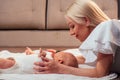 newborn baby in a tender embrace of mother lying on the bed in the bedroom Royalty Free Stock Photo