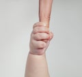 Newborn baby touching his mother hand on gentle white background Royalty Free Stock Photo