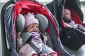 Newborn baby twins girl sitting in a car seat