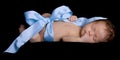 Newborn Baby Wrapped up in Ribbon and Bow Sleeping