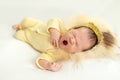 A newborn baby yawns sweetly on a white background, in a warm knitted suit, space for text Royalty Free Stock Photo