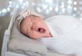 Newborn baby yawns, white background, copy space. Sleep sippers, funny face of a child, emotions. daily routine, time to sleep. Royalty Free Stock Photo