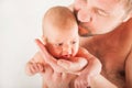 Newborn on the bed with his father close-up. The concept of the relationship of children and parents from birth.