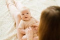 Newborn boy lies on his mother`s lap and looks, the mother holds his hands. The concept of happy motherhood Royalty Free Stock Photo