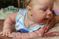 Newborn boy lies on his stomach on the bed and looking away. baby boy in the early days of home. Royalty Free Stock Photo