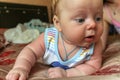 Newborn boy lies on his stomach on the bed and looking away. baby boy in the early days of home. Royalty Free Stock Photo