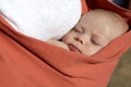 Newborn boy sleeping in baby sling carrier Royalty Free Stock Photo