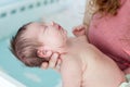 Newborn Caucasian baby fall into a deep sleep on female hands, throw back head