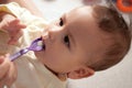 Newborn child drinking water or medicine cough syrup with spoon, close up. little baby drink medical syrup Royalty Free Stock Photo