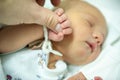 A newborn child on the first day of his birth in the maternity hospital holds his father`s finger Royalty Free Stock Photo